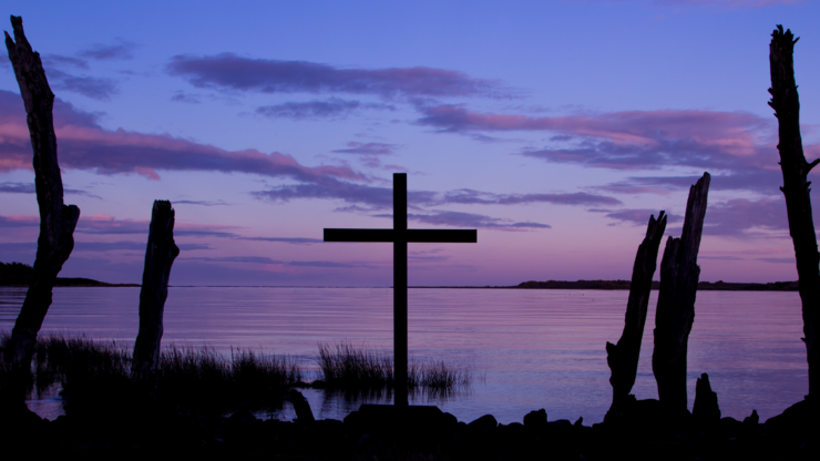 Early morning colorful sky behind a cross.