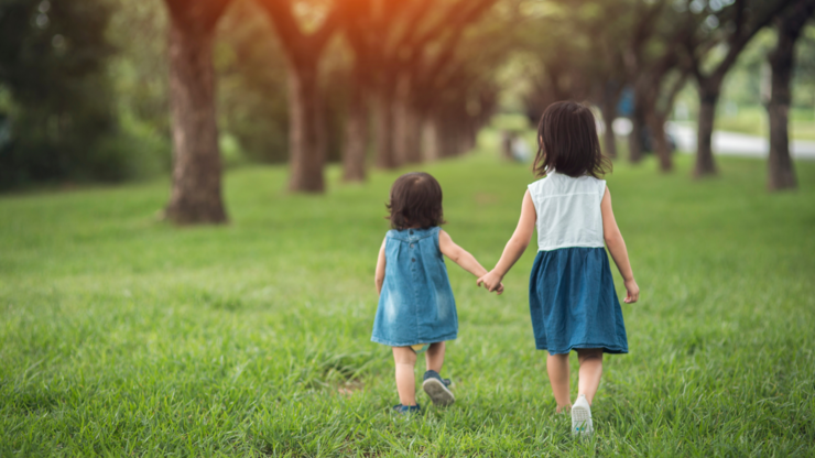 Two little sisters holding each other hands and running forward.Vintage color