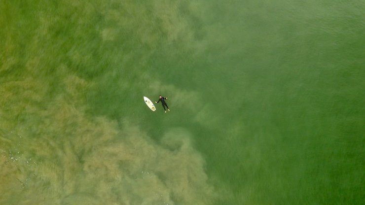 Travis Hensley relaxing laying in the ocean as he wait for a set to roll in